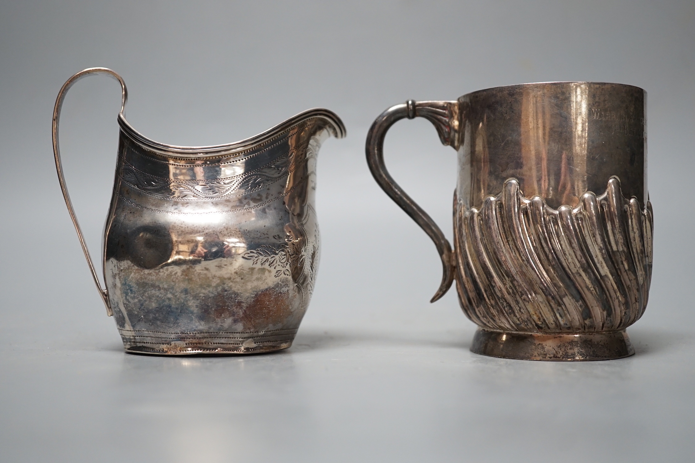 A George III silver cream jug, London, 1800, a later silver mug and a white metal and enamelled initiallled clip?, gross 8.5oz.